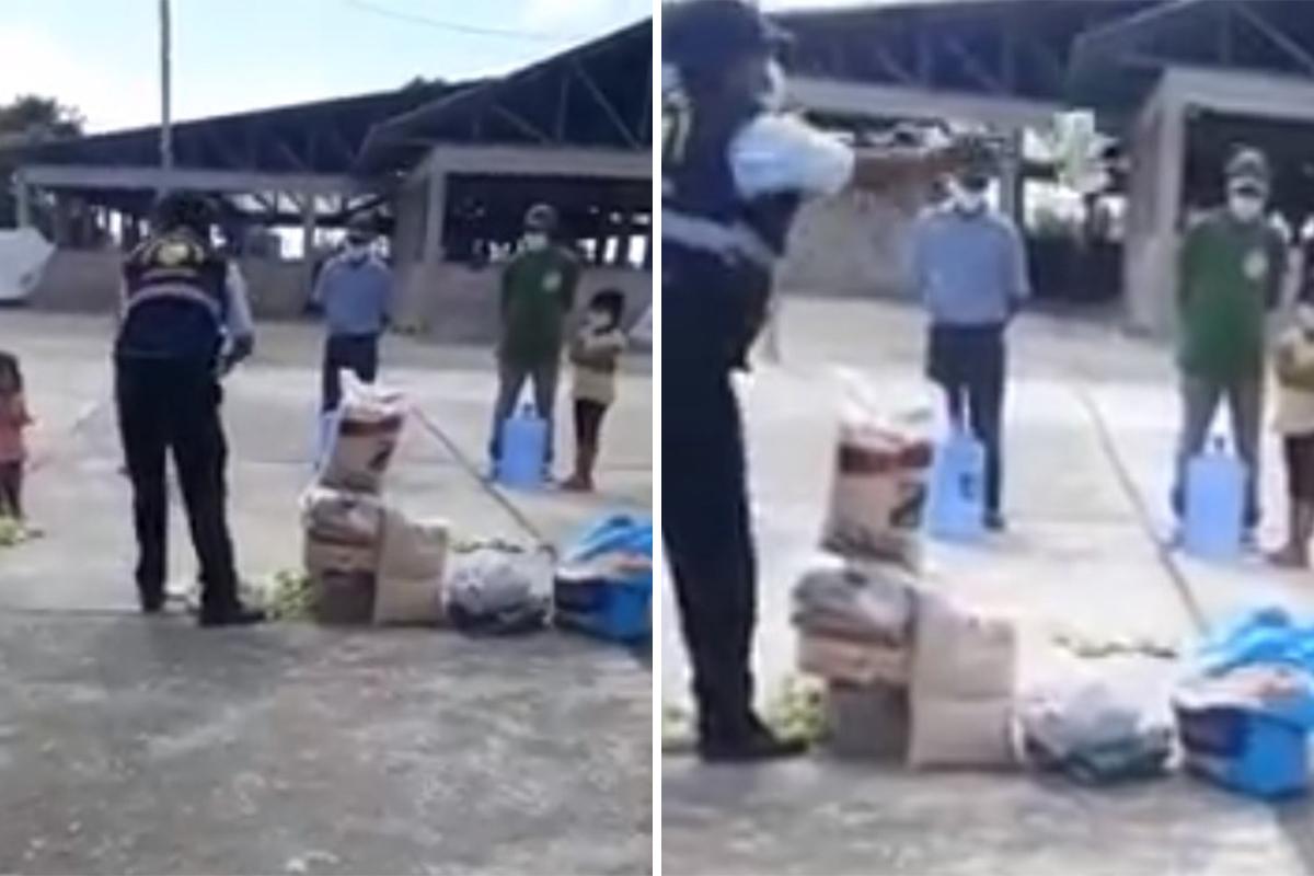 El jefe de Seguridad Ciudadana les arroja víveres a ciudadanos que se encontraban en el Centro de Aislamiento COVID-19 de Inambari. Foto: Captura de vídeo.